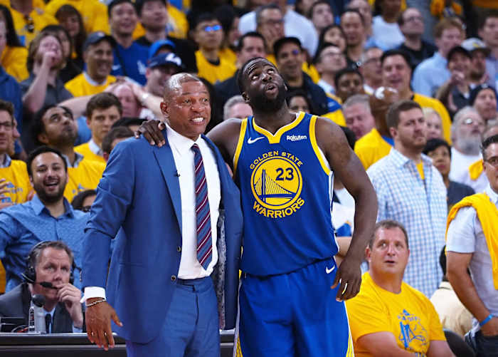 Golden State Warriors forward Draymond Green (23) talks to LA Clippers head coach Doc Rivers (left)